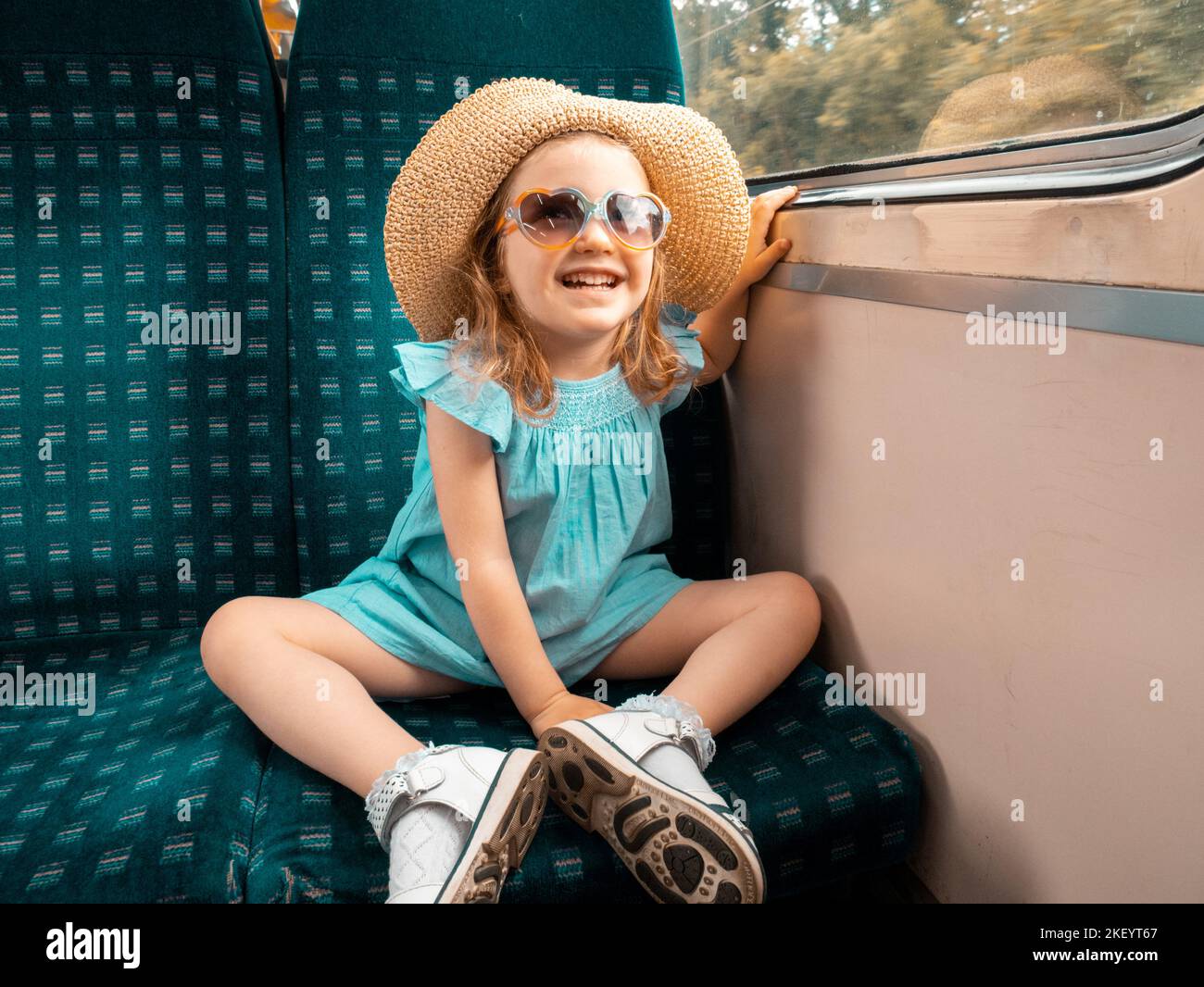 Junge drei Jahre altes Mädchen aus einem großen nördlichen Zugfenster, London, UK Stockfoto