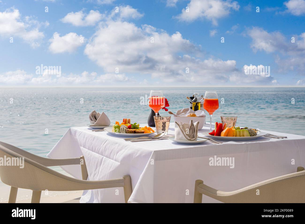 Luxuriöser Frühstückstisch mit Essen für zwei Personen mit wunderschönem tropischen Meerblick im Hintergrund. Morgen paar Zeit Sommerurlaub und romantischen Urlaub Konzept Stockfoto