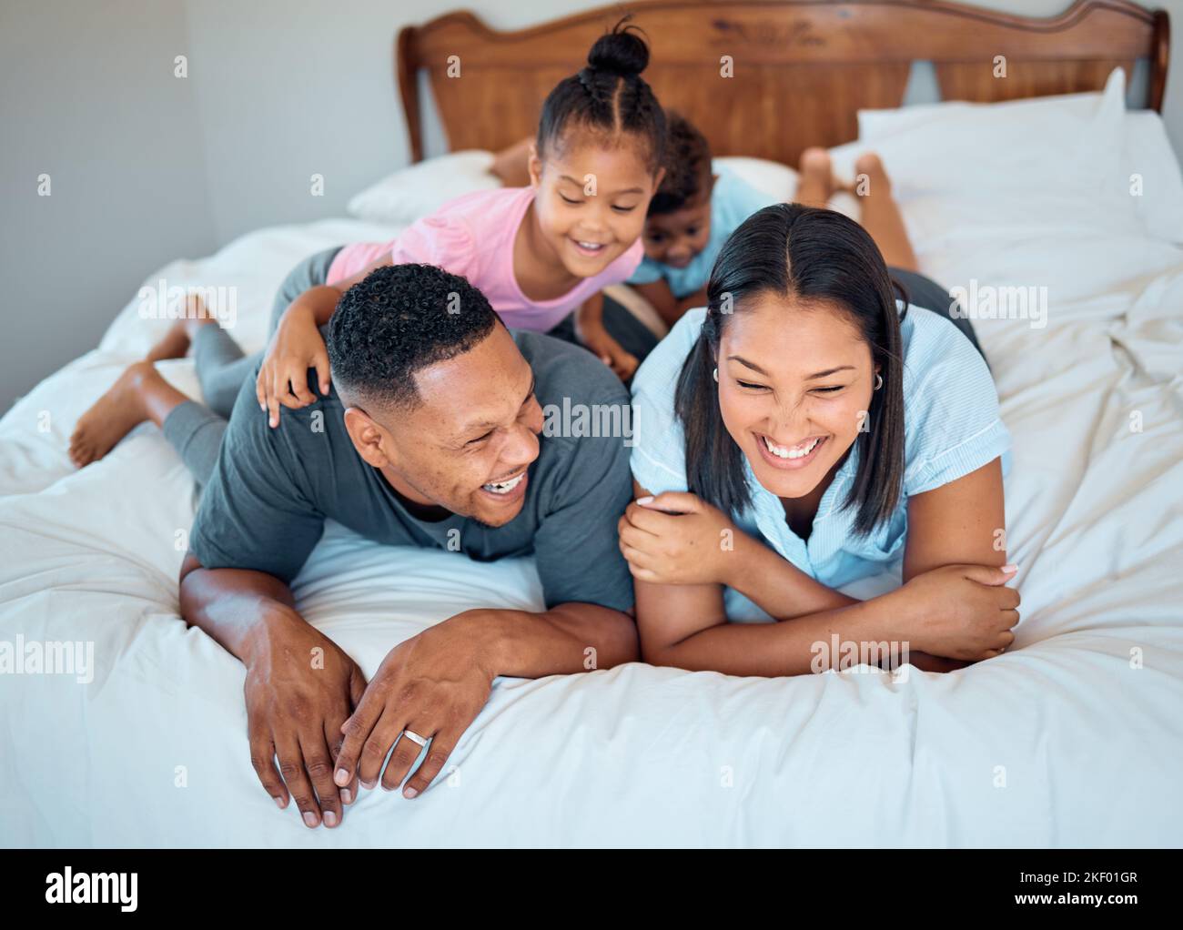 Glückliche Familie mit Kindern, lächeln und liegen zu Hause auf dem Bett, Mutter und Vater mit Kindern zusammen in Mexiko. Liebe, Spaß und Familie Zeit für Vater, Mutter und Stockfoto
