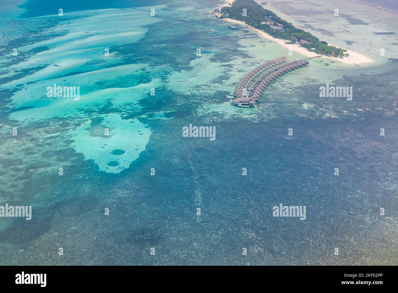 Blick auf die Malediven aus der Vogelperspektive. Wunderschönes blaues Meer und luxuriöse Wasservillen. Luftaufnahme mit dem Wasserflugzeug auf das Atoll der Malediven und das Korallenriff Stockfoto
