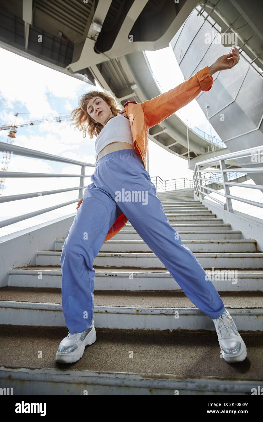 Dynamische Ganzkörperaufnahme einer jungen Frau, die im Stadtgebiet tanzt und Streetwear trägt Stockfoto