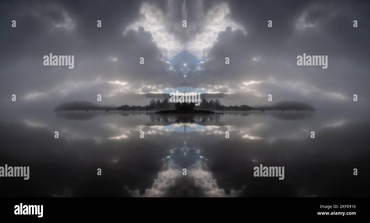 Am frühen Morgen hängt Nebel und niedrige Wolken über Derwentwater, English Lake District. Zusammengesetztes Spiegelbild. Stockfoto