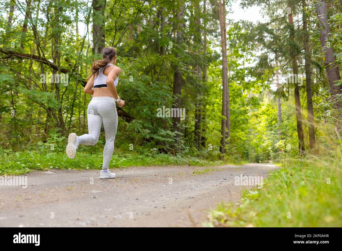 Frau, Die Während Des Trainings Im Freien Im Wald Läuft Stockfoto