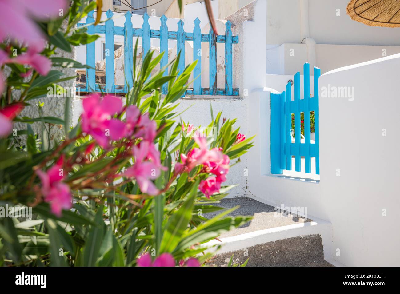 Fantastischer Reisehintergrund, Santorin urbane Straßenlandschaft. Blaue Tür- oder Tortreppe und weiße Architektur unter sonnigem Himmel. Fantastische Sommerszene Stockfoto