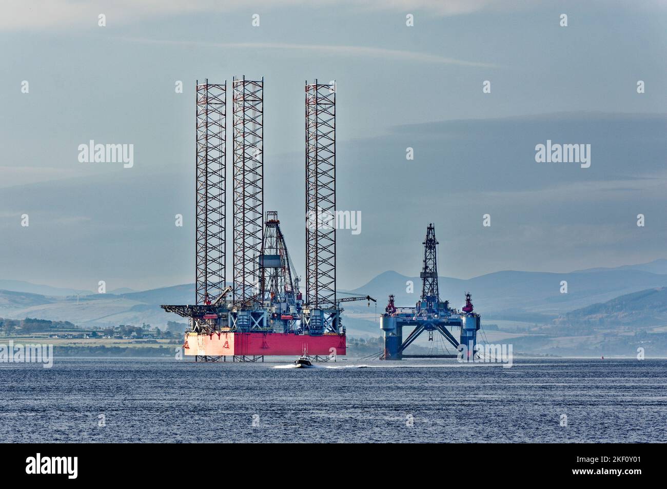 Cromarty Firth Scotland kleines Pilotboot, das stillgelegte Ölbohrinseln passiert Stockfoto