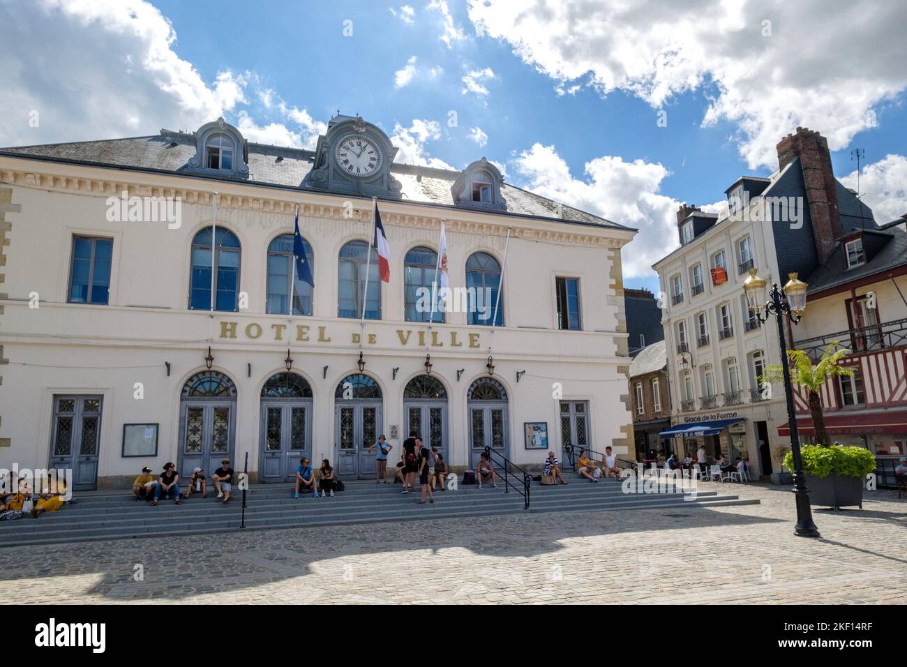 Menschen, die auf den Stufen des Hotels de Ville, Rathausgebäude, von Honfleur, Calvados, Normandie sitzen Stockfoto