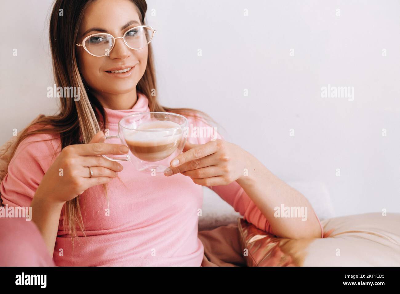 Entspanntes Mädchen am Morgen im Pyjama zu Hause Kaffee trinken .Inner peace.The Mädchen sitzt bequem auf dem Sofa und Kaffee trinken träumen Stockfoto