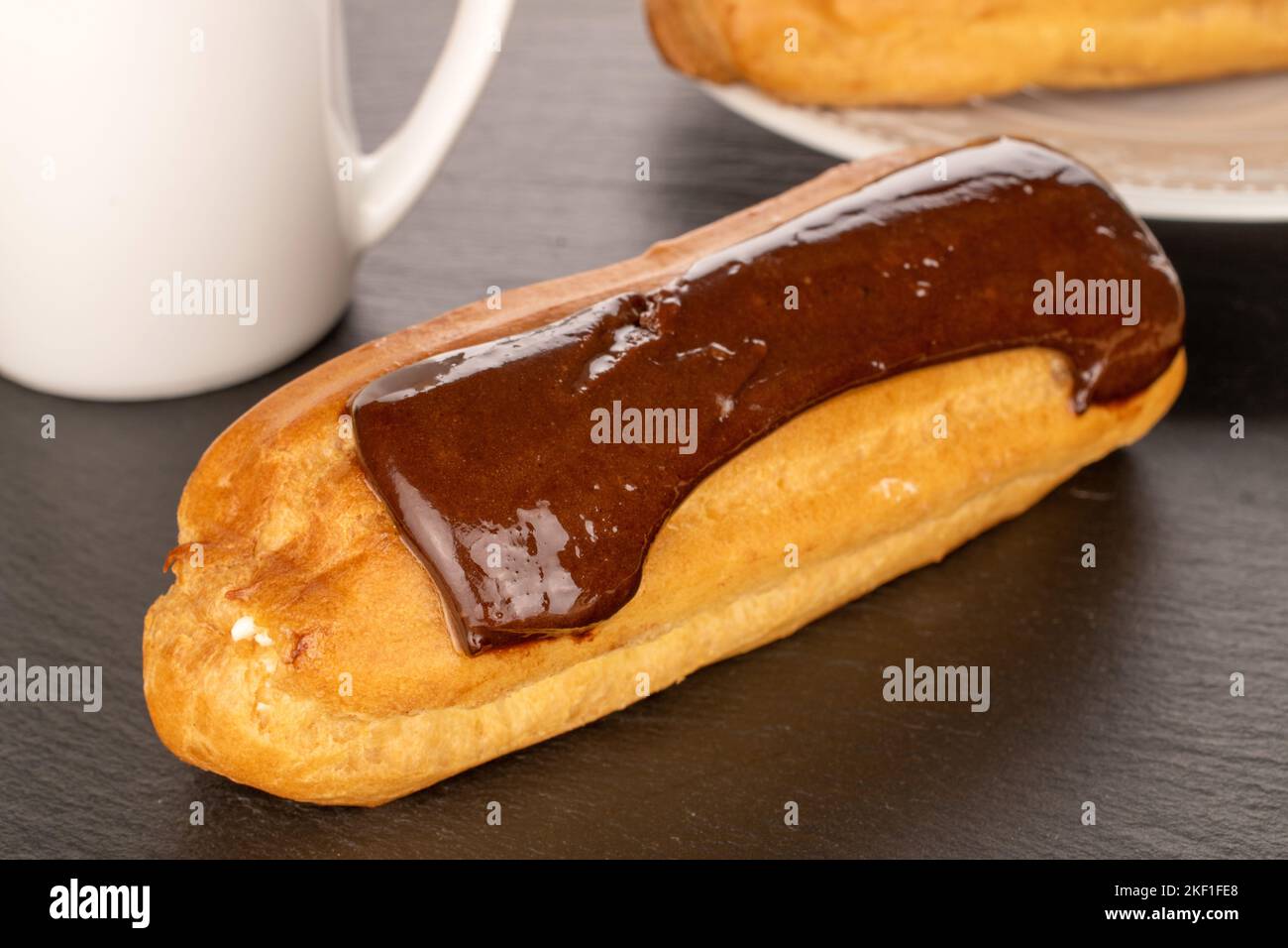 Ein süßer eclair auf einem Schieferstein, Makro. Stockfoto