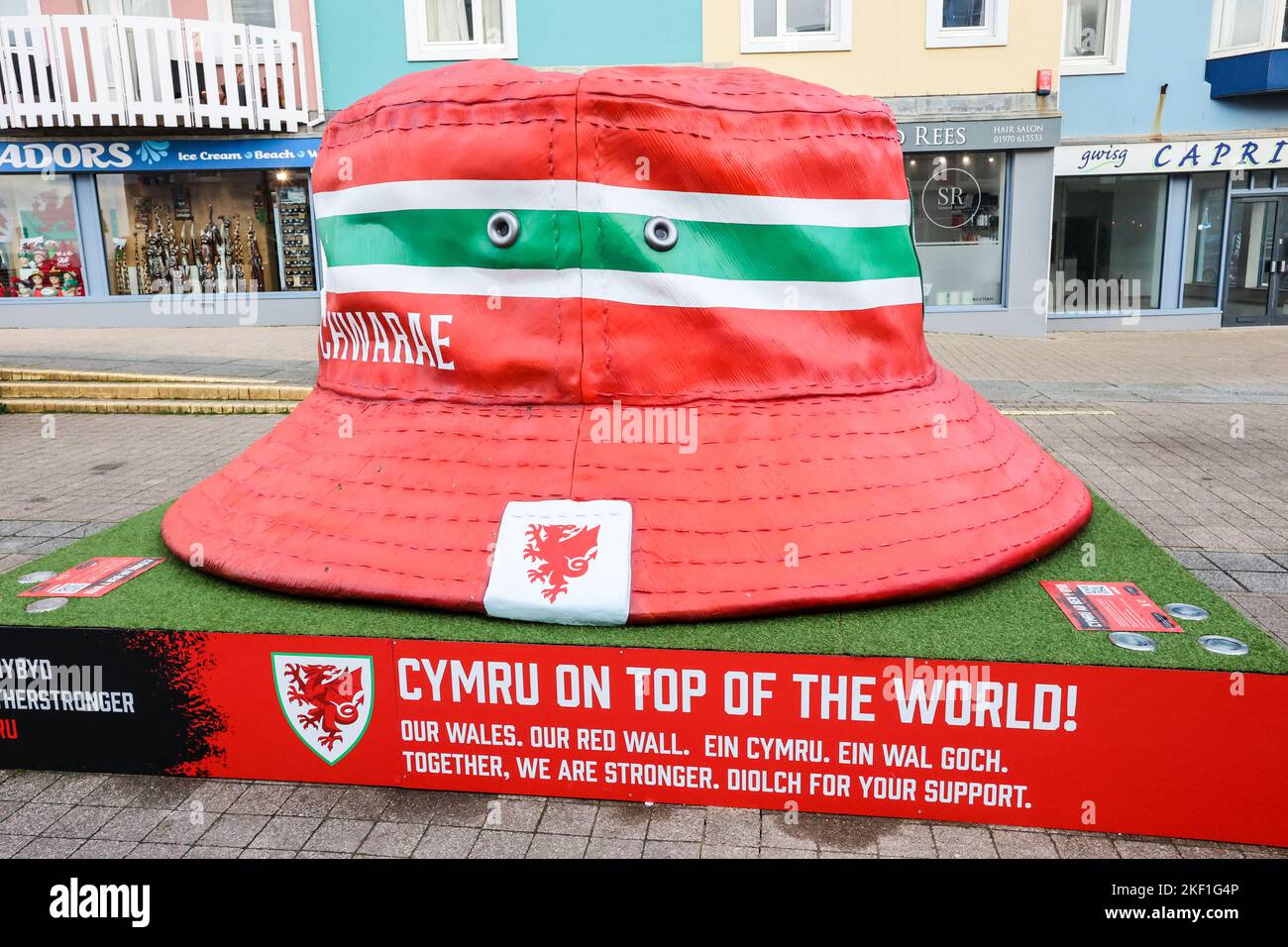 Aberystwyth, Wales, Großbritannien. 15.. November 2022. Riesige kultige walisische Fußballfans mit Hutstruktur, Aberystwyth, Wales, Großbritannien. Groß, 10 Fuß mal 10 Fuß, Kunstinstallation, im Zentrum von Aberystwyth ausgestellt, ist der Eimer Hut zu einem Symbol der Fans der Fußballmannschaft von Wales geworden. Die Statue wurde errichtet, es gibt fünf in walisischen Städten, um die walisische Nationalmannschaft zu feiern, die das Finale der Weltmeisterschaft zum ersten Mal seit 1958 erreicht hat, ein Zeitraum von 64 Jahren, seit sie das letzte Mal bei der Weltmeisterschaft gespielt haben. Kredit: Paul Quayle/Alamy Live Nachrichten Stockfoto