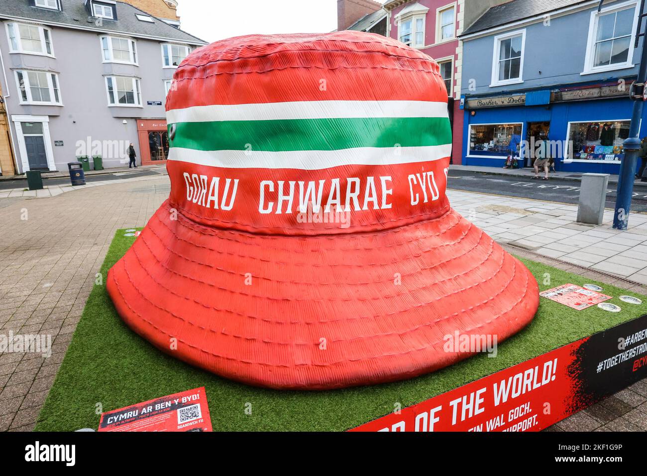 Aberystwyth, Wales, Großbritannien. 15.. November 2022. Riesige kultige walisische Fußballfans mit Hutstruktur, Aberystwyth, Wales, Großbritannien. Groß, 10 Fuß mal 10 Fuß, Kunstinstallation, im Zentrum von Aberystwyth ausgestellt, ist der Eimer Hut zu einem Symbol der Fans der Fußballmannschaft von Wales geworden. Die Statue wurde errichtet, es gibt fünf in walisischen Städten, um die walisische Nationalmannschaft zu feiern, die das Finale der Weltmeisterschaft zum ersten Mal seit 1958 erreicht hat, ein Zeitraum von 64 Jahren, seit sie das letzte Mal bei der Weltmeisterschaft gespielt haben. Kredit: Paul Quayle/Alamy Live Nachrichten Stockfoto