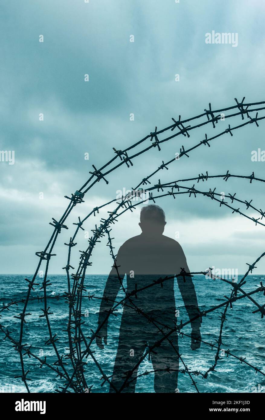 Mann, der durch einen Stacheldrahtzaun am Strand schaute. Grenzkontrollübertritt, Migranten, Asylbewerber, Migranten, Menschenschmuggel... Konzept Stockfoto