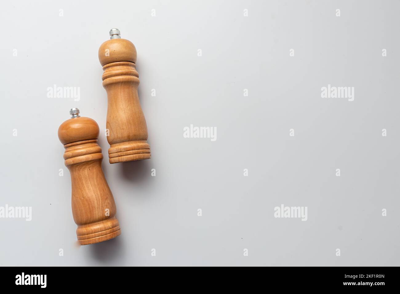 Salz- und Pfefferstreuer aus Holz, Schleifmaschinen auf einem weißen Tisch mit weißem Hintergrund Stockfoto