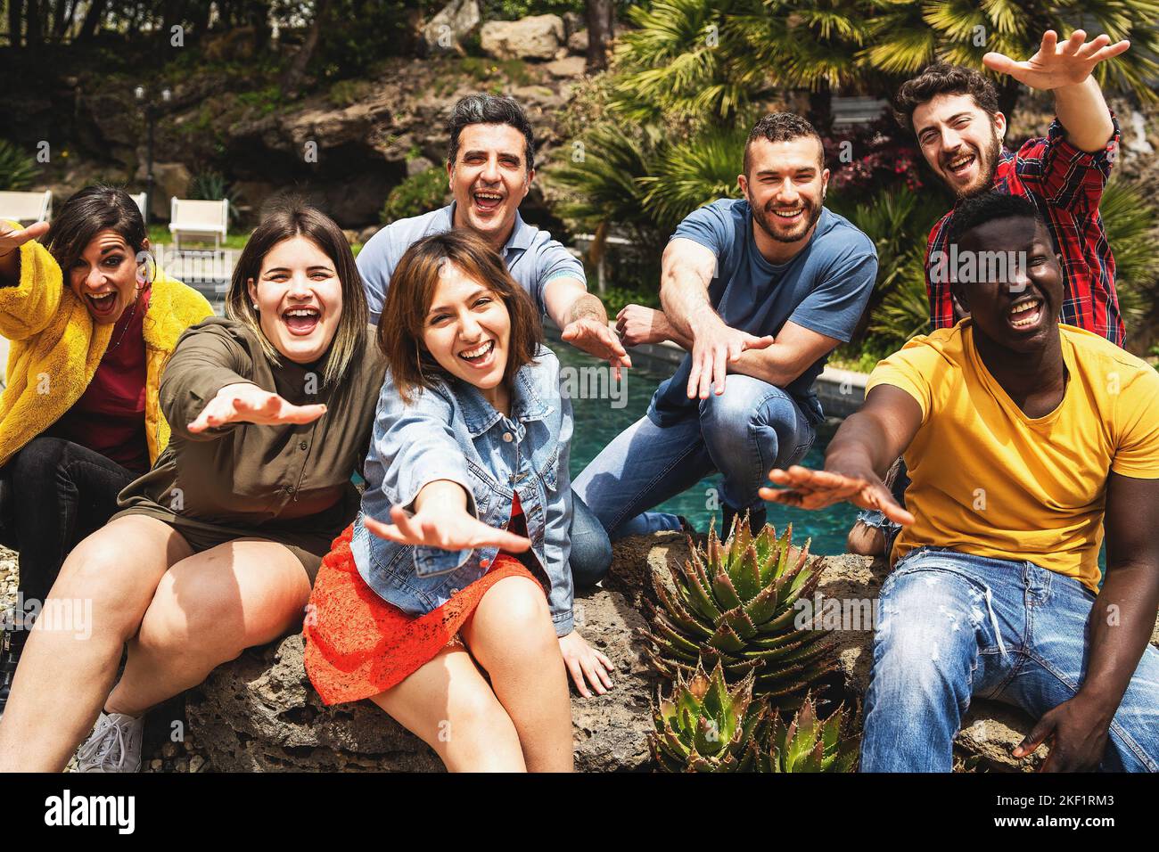 Fröhliche multiethnische vielfältige Gruppe von jungen Menschen, die Spaß haben zusammen posieren Blick auf die Kamera mit ausgestreckten Armen - glückliche Menschen Lebensstil Konz Stockfoto