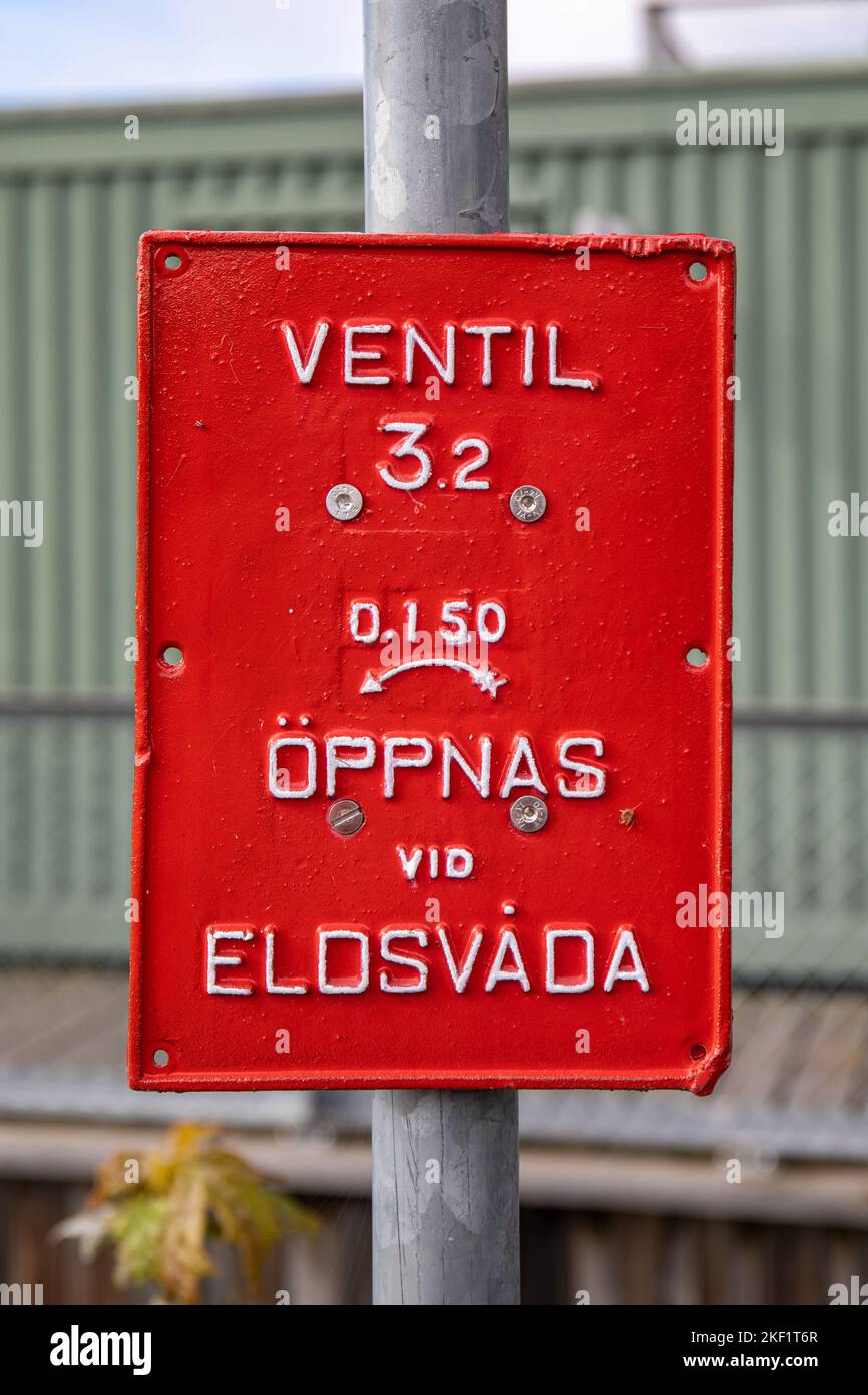 Ventil - öppnas vid eldsvåda. Marktschild oder Schild für rote Hydranten im Stadtteil Djugården in Stockholm, Schweden. Stockfoto