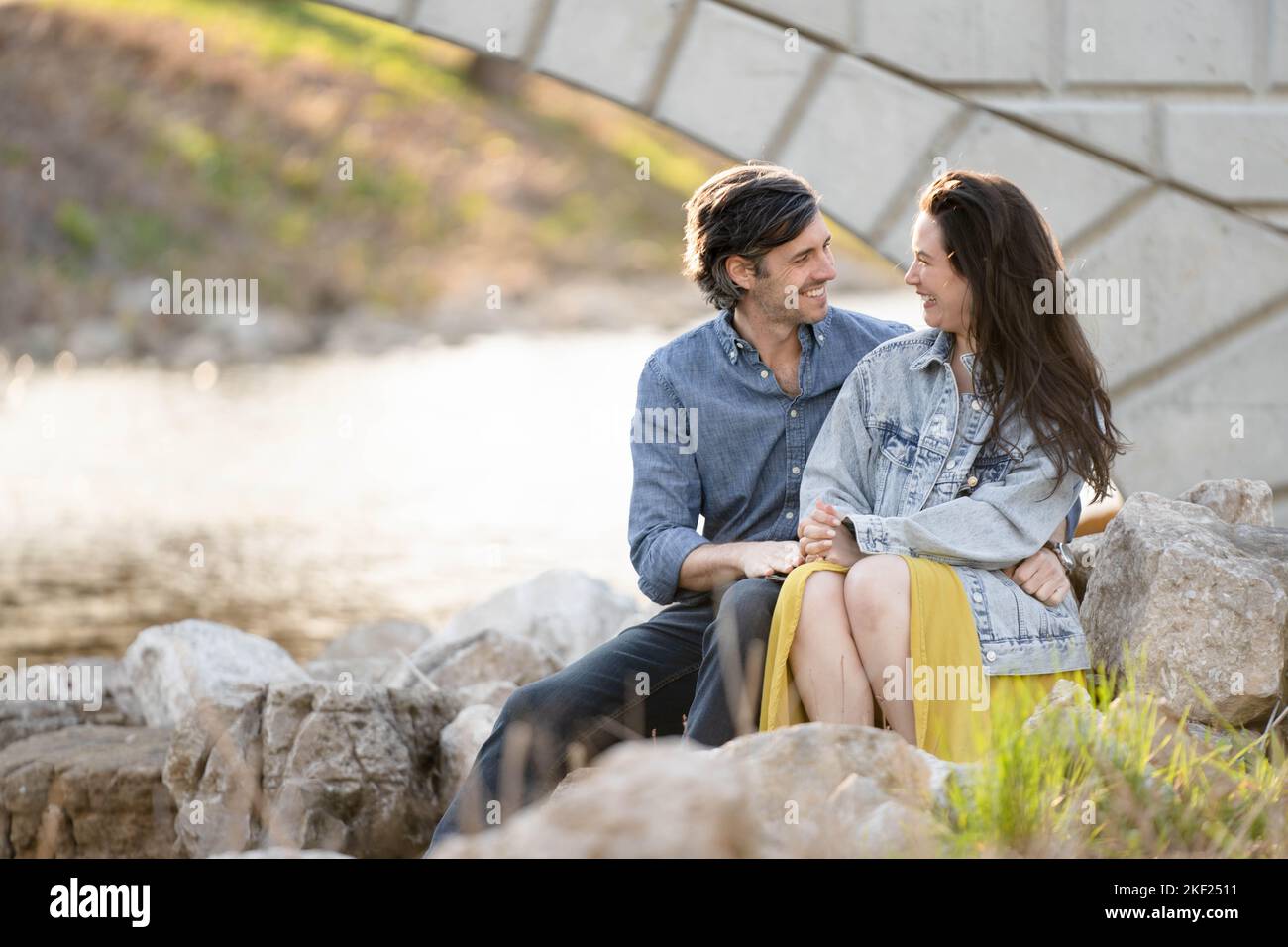 Ein Paar an einer Brücke im Forest Park, flirtet und erkundet zusammen. Stockfoto