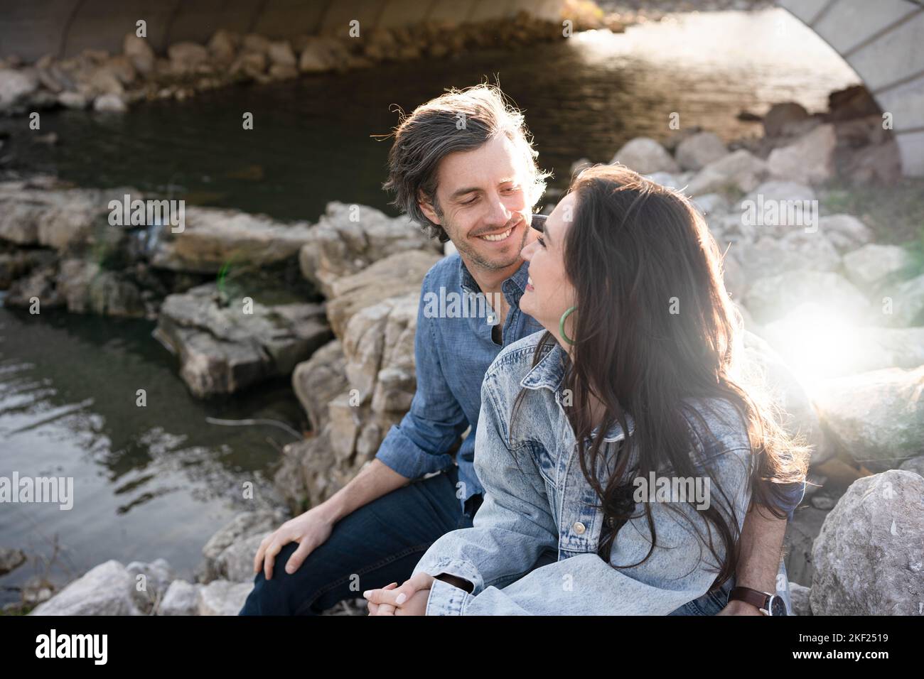 Ein Paar an einer Brücke im Forest Park, flirtet und erkundet zusammen. Stockfoto