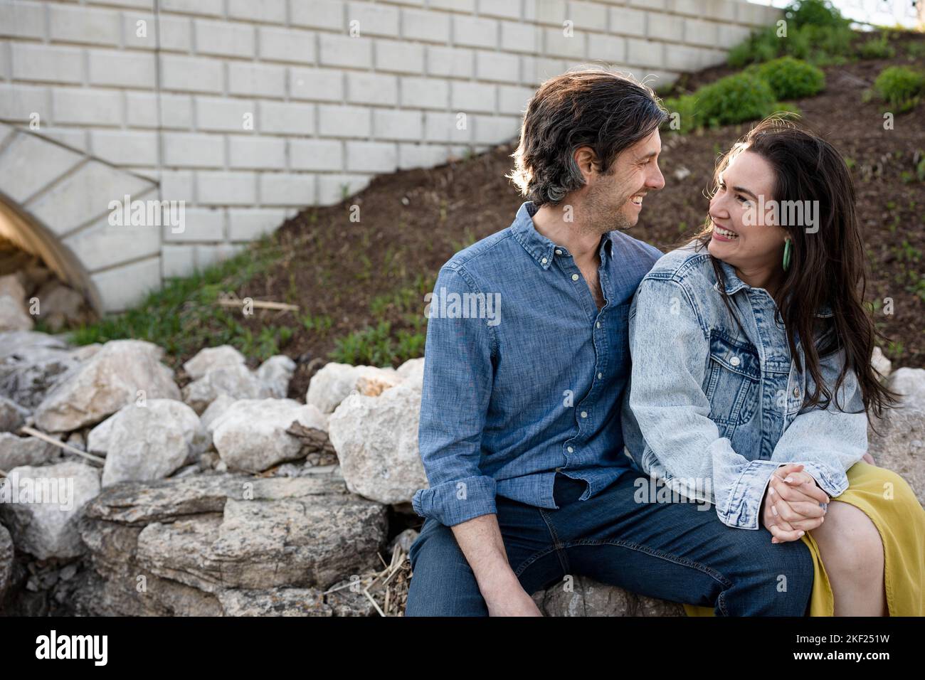 Ein Paar an einer Brücke im Forest Park, flirtet und erkundet zusammen. Stockfoto