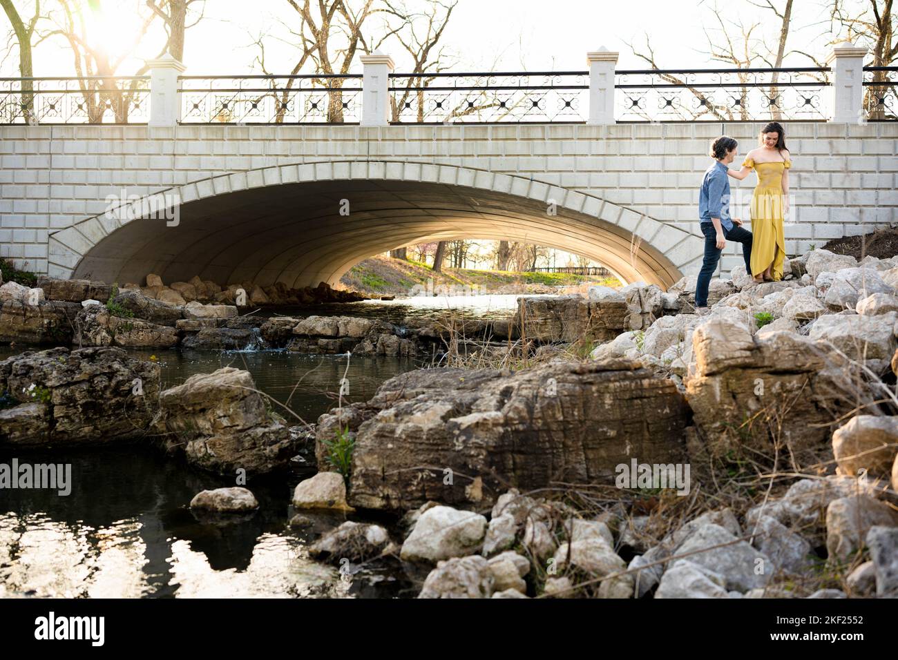 Ein Paar an einer Brücke im Forest Park, flirtet und erkundet zusammen. Stockfoto