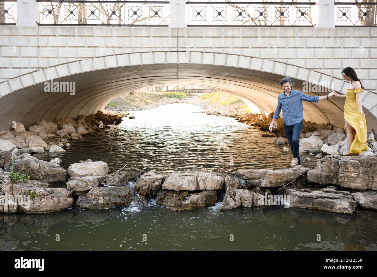 Ein Paar an einer Brücke im Forest Park, flirtet und erkundet zusammen. Stockfoto