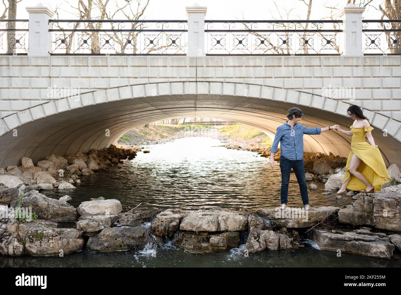 Ein Paar an einer Brücke im Forest Park, flirtet und erkundet zusammen. Stockfoto
