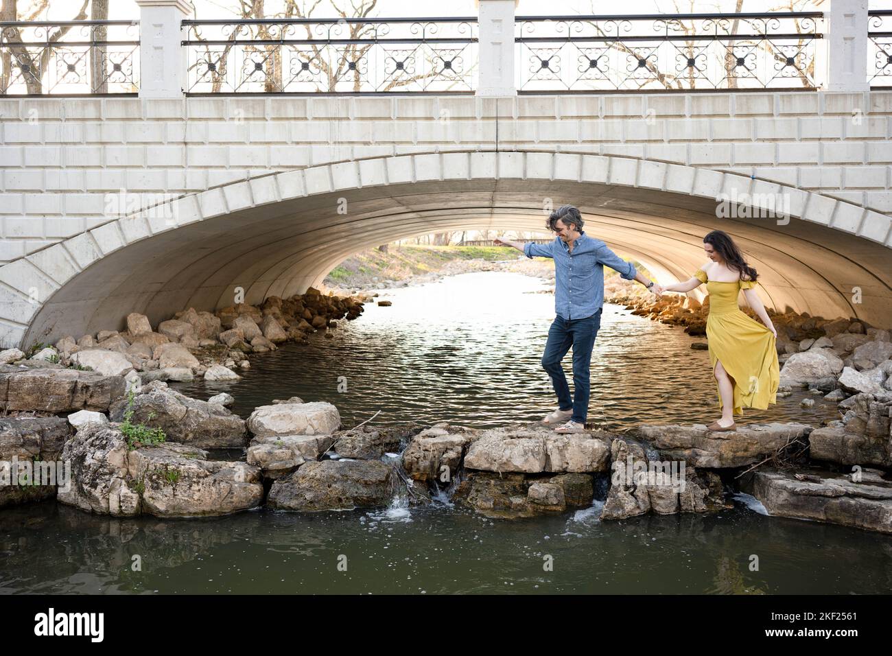 Ein Paar an einer Brücke im Forest Park, flirtet und erkundet zusammen. Stockfoto
