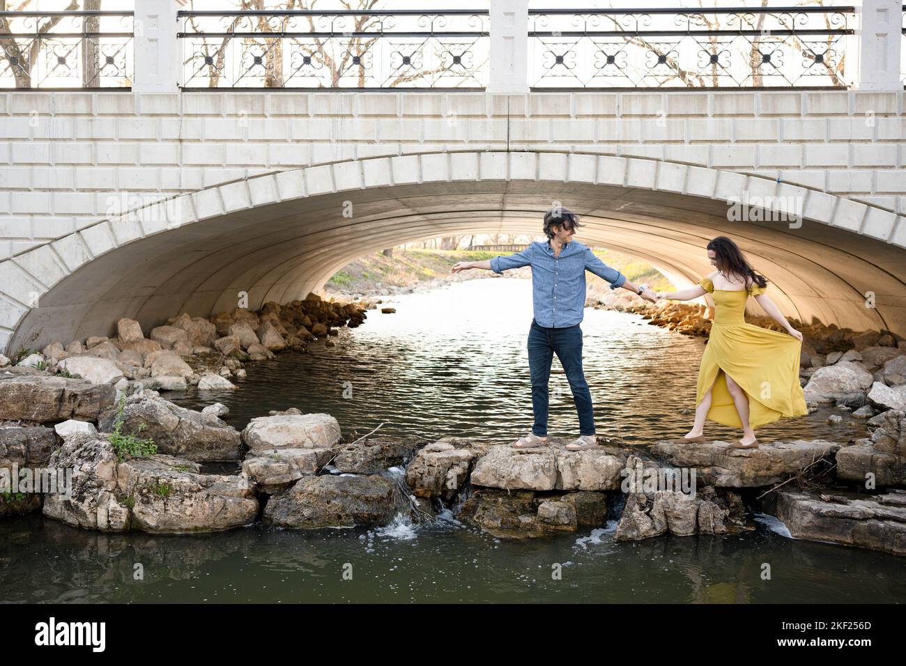 Ein Paar an einer Brücke im Forest Park, flirtet und erkundet zusammen. Stockfoto