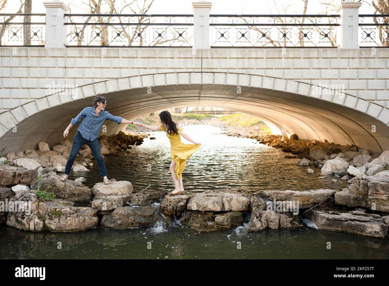 Ein Paar an einer Brücke im Forest Park, flirtet und erkundet zusammen. Stockfoto
