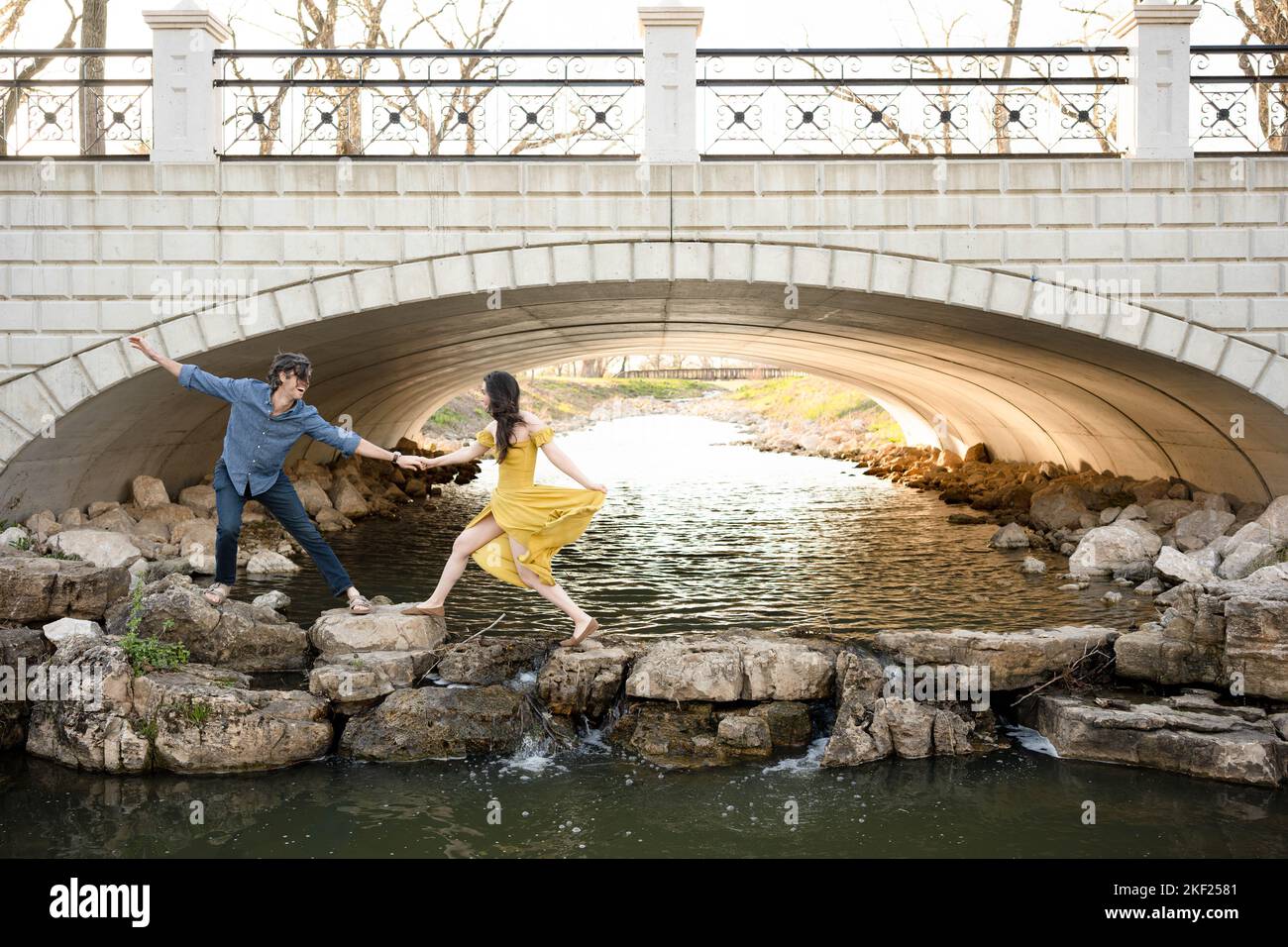 Ein Paar an einer Brücke im Forest Park, flirtet und erkundet zusammen. Stockfoto