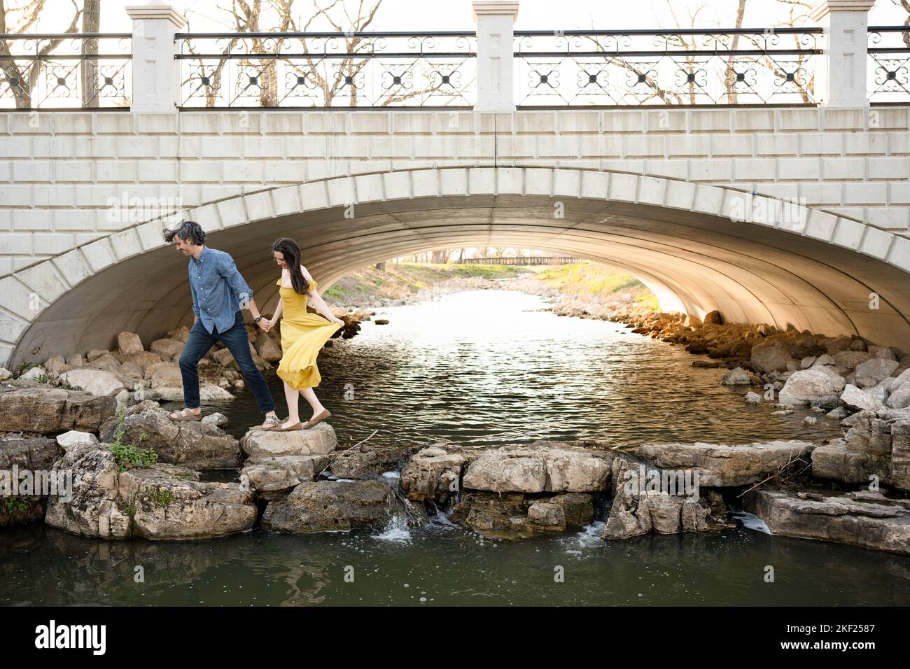 Ein Paar an einer Brücke im Forest Park, flirtet und erkundet zusammen. Stockfoto