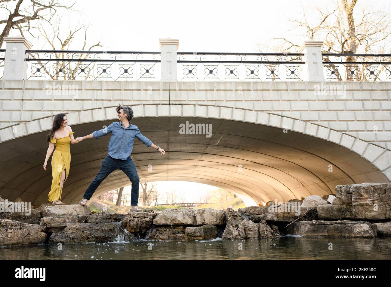 Ein Paar an einer Brücke im Forest Park, flirtet und erkundet zusammen. Stockfoto