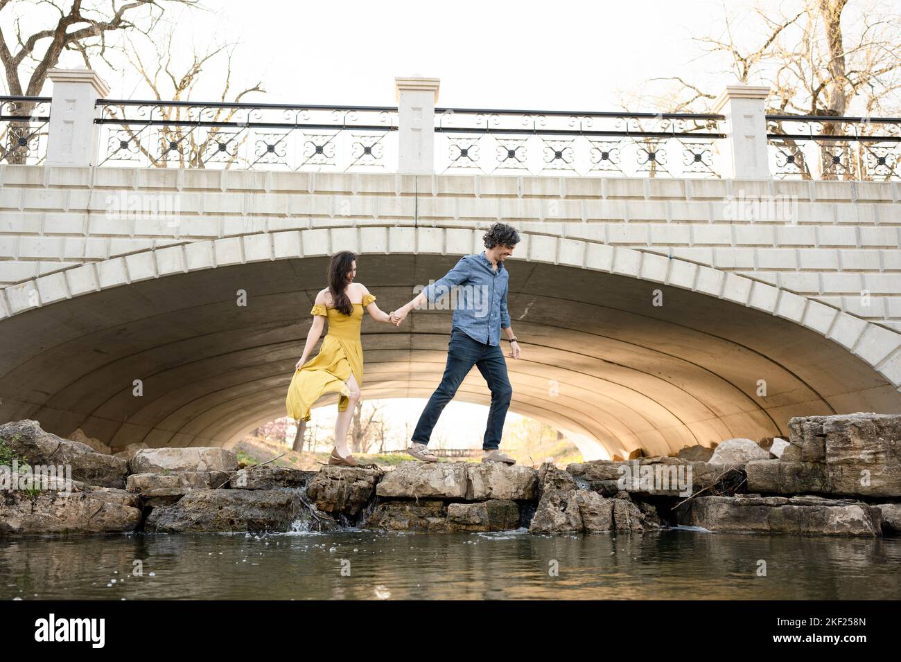 Ein Paar an einer Brücke im Forest Park, flirtet und erkundet zusammen. Stockfoto