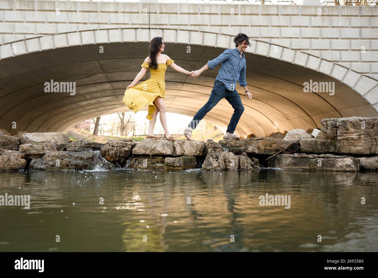 Ein Paar an einer Brücke im Forest Park, flirtet und erkundet zusammen. Stockfoto