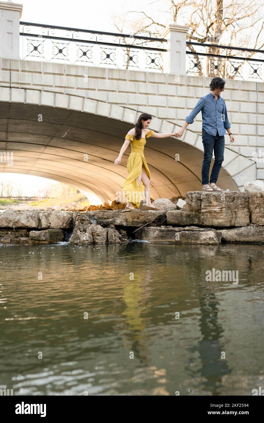 Ein Paar an einer Brücke im Forest Park, flirtet und erkundet zusammen. Stockfoto