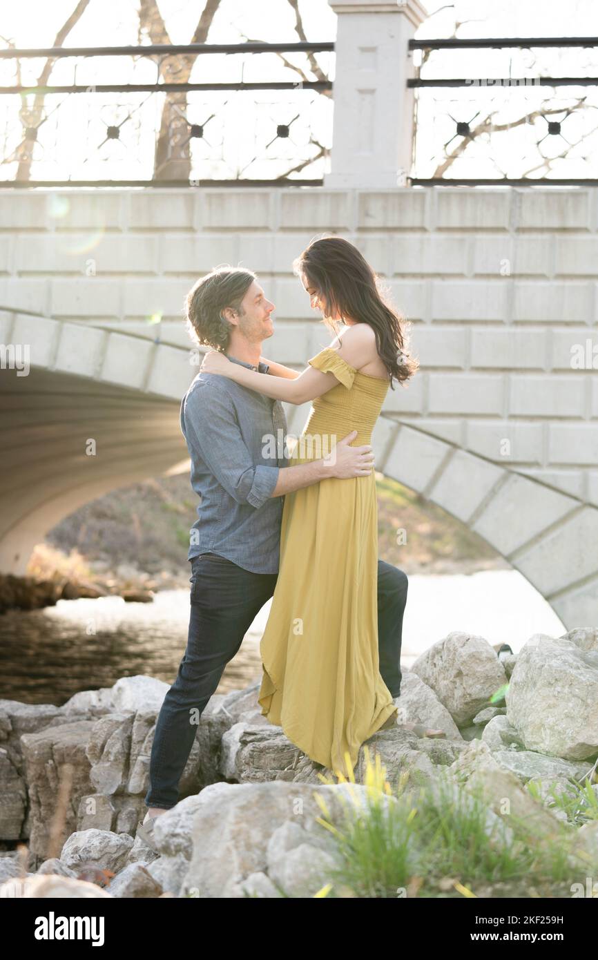 Ein Paar an einer Brücke im Forest Park, flirtet und erkundet zusammen. Stockfoto