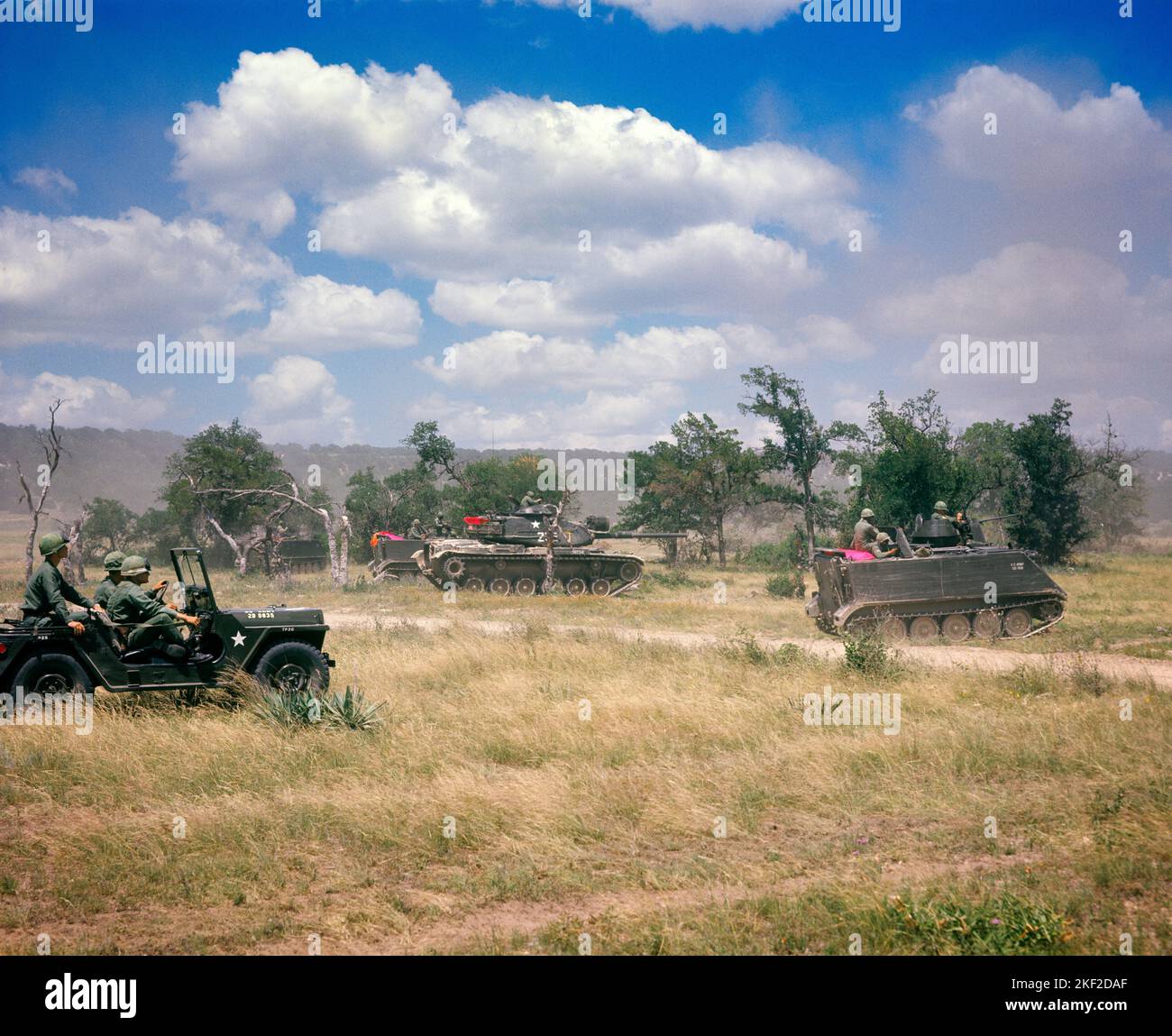 1970S UNITED STATES ARMY M60 PANZER M113 GEPANZERTE PERSONENTRÄGER UND KOMMANDOOFFIZIERE REITEN IN EINEM JEEP TRAINING WÄHREND VIETNAM - KM1983 HAR001 HARS MÄNNER RISIKO VERTRAUEN TRANSPORT NORDAMERIKA FREIHEIT NORDAMERIKANISCHER SCHUTZ STÄRKE STRATEGIE MUT UND AUFREGUNG WISSEN FÜHRUNG MÄCHTIGE PANZER STOLZ EIN IN AUF AUTORITÄT BERUFE UNIFORMEN KONZEPTIONELLE FAHRZEUGE PANZERTRÄGER OFFIZIERE BEFEHL JEEP MITTLEREN ERWACHSENEN MITTLEREN ERWACHSENEN MANN PERSONAL JUNGER ERWACHSENER MANN, DER WÄHREND HAR001 JEEPS MANÖVERN ALTMODISCH GEPANZERT WURDE Stockfoto