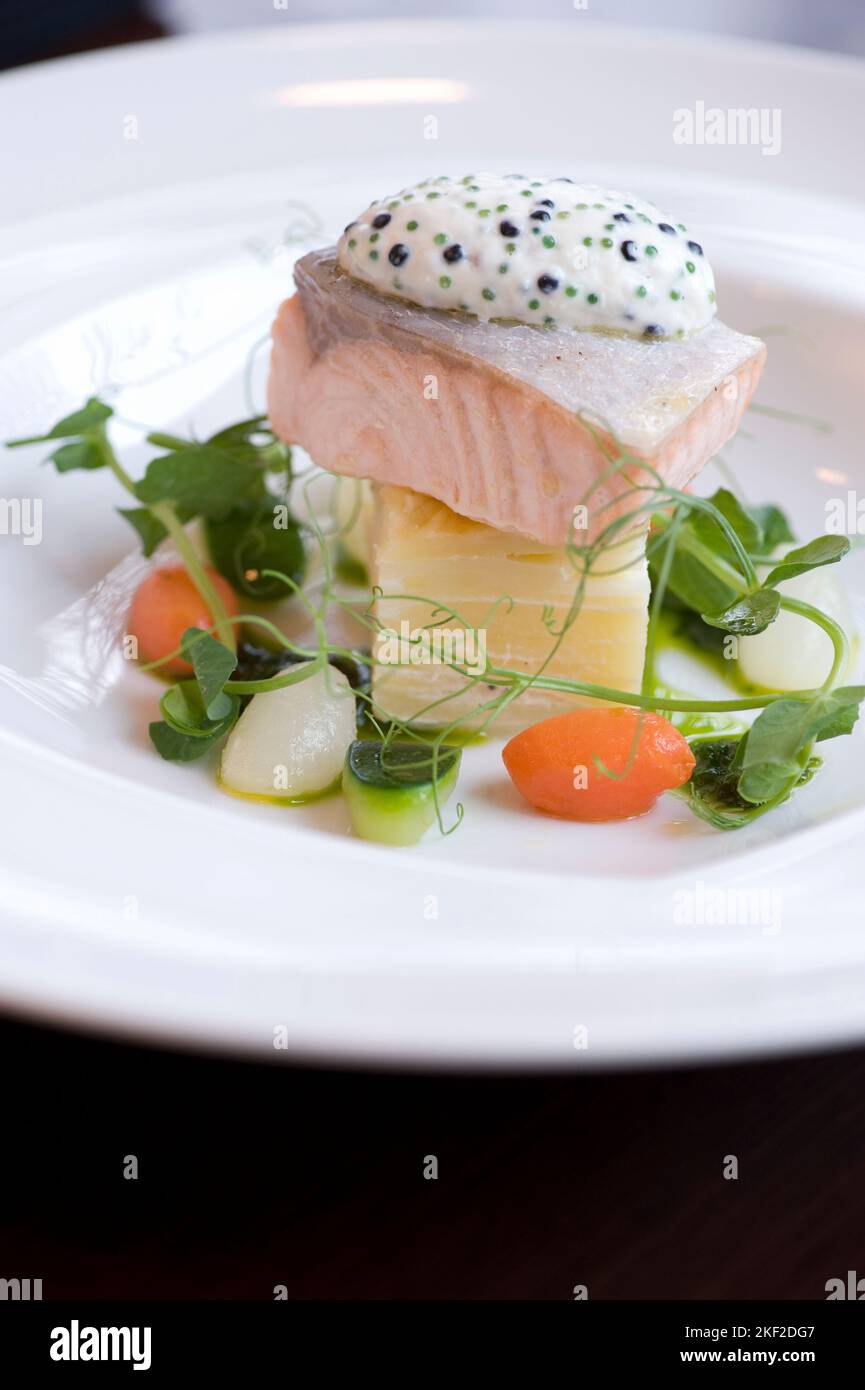 Lachs serviert mit Gemüse, Kräutern und Pesto-Sauce Stockfoto