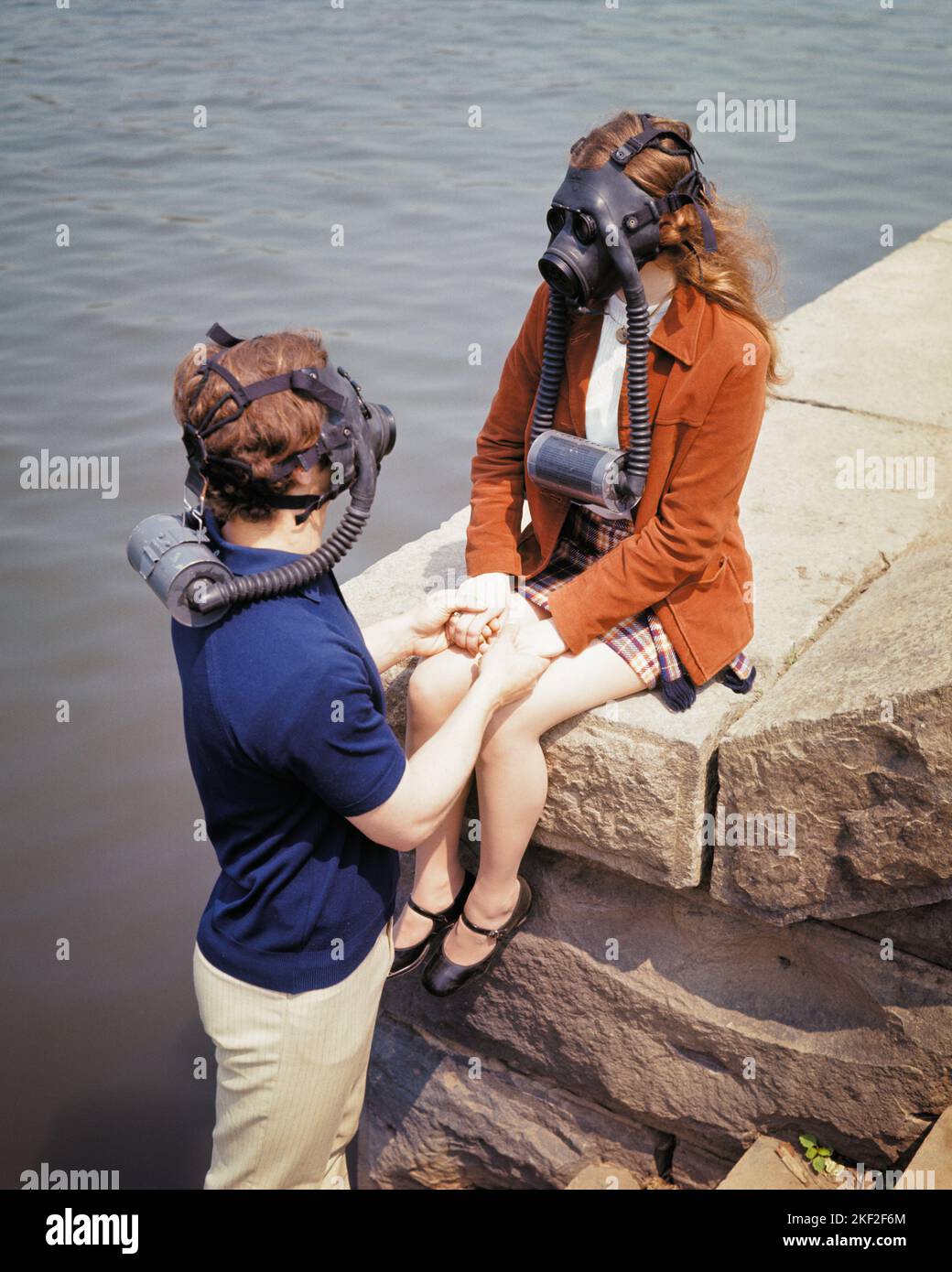 1960S 1970S JUNGES PAAR STEIN PIER HÄLT HÄNDE FRAU SITZT IN GASMASKEN - KS6901 HAR001 HARS FRAUEN MASKIERT DIE NATUR COPY SPACE FREUNDSCHAFT HALBE LÄNGE DAMEN PERSONEN INSPIRATION FÜRSORGLICHE GEFAHR MÄNNER RISIKO TEENAGER JUNGE GEFAHR TRAURIGKEIT PIER KATASTROPHE TRÄUME HOHEN WINKEL GEFÄHRLICHER UMWELTSCHUTZ GIFTIG RISKANT ZU GEFÄHRLICHEN BEZIEHUNGEN GEFAHR UNSICHERER KLIMAWANDEL VERBINDUNG KONZEPTIONELLE SCHÄDLICHE KONTAMINATION GEFÄHRDET TOXINE ZUSAMMENARBEIT UMWELT TREIBHAUSGASE IDEEN LÖSUNGEN ZUSAMMENGEHÖRIGKEIT KAUKASISCHE ETHNIE HAR001 ALTMODISCH Stockfoto