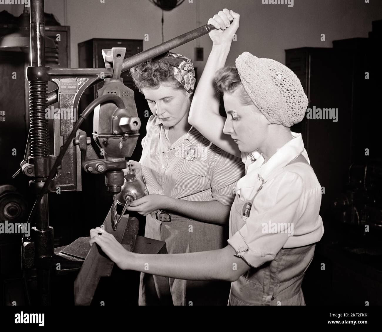 1940S ZWEI MÄDCHEN IN OVERALLS ARBEITEN UND KLEIDEN SICH HAARNETZ & SCHAL MIT EINER BOHRPRESSE UND ÖL KÖNNEN WEIBLICHE DEFENSIVE ARBEITER - Q43390 CPC001 HARS WW2 JOBS KOPIEREN RAUM FREUNDSCHAFT HALBLANGE DAMEN PERSONEN INSPIRATION OVERALLS B&W FREIHEIT GESCHICKLICHKEIT BERUF FÄHIGKEITEN BETRIEBS- UND WELTKRIEGE ARBEITERSTOLZ WELTKRIEG WELTKRIEG ZWEI WELTKRIEG II BESCHÄFTIGUNG BERUFE KONZEPTIONELLE DEFENSIVE UNTERSTÜTZUNG WELT WAR 2 MITARBEITER ZUSAMMENARBEIT MID-ADULT MID-ADULT FRAU LÖSUNGEN ZWEISAMKEIT & SCHWARZ-WEISS KAUKASISCHEN ETHNIE ARBEIT ALTMODISCHEN ARBEITSKLEIDUNG Stockfoto