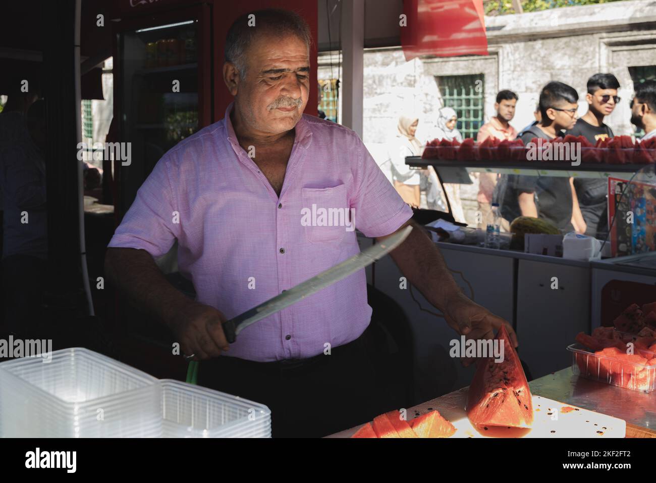 Istanbul, Türkei - 1 2022. Oktober: Ein traditioneller türkischer Straßenhändler im Touristenviertel Sultanahmet verkauft große Wassermelonen aus einer Lebensmittelstraße Stockfoto