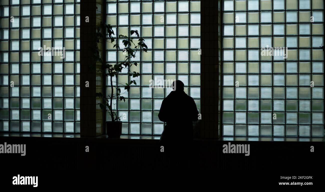 Silhouette eines Mannes vor dem Hintergrund eines großen Fensters Stockfoto