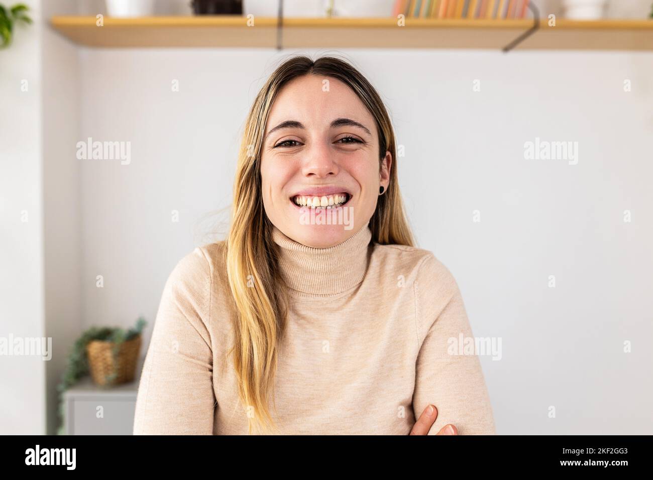 POV-Videoanruf-Bildschirm einer jungen erwachsenen Frau, die bei einem virtuellen Meeting vor der Kamera lächelt Stockfoto