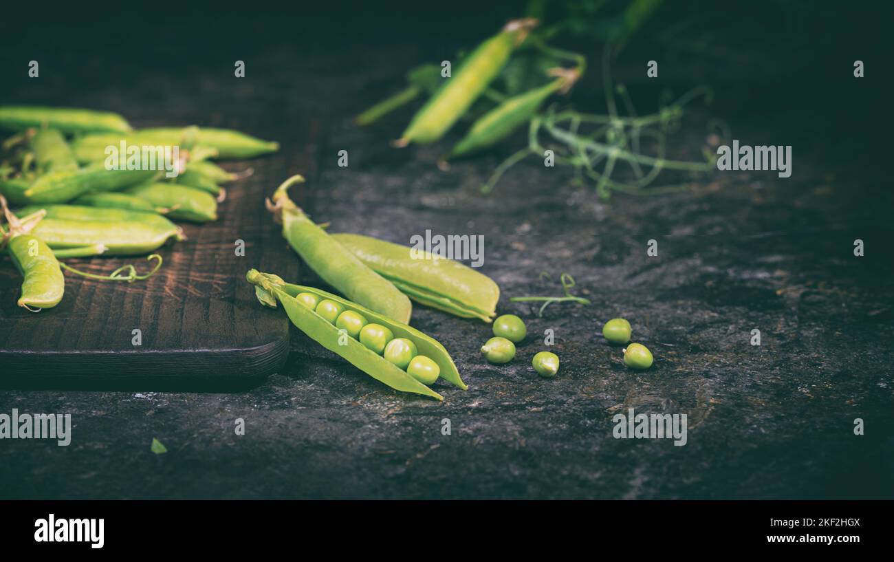 Ländliche Stillleben - Ansicht der Erbse Ernte, selektiver Fokus, Nahaufnahme auf einem dunklen Hintergrund mit Platz für Text. Das Erntekonzept Stockfoto