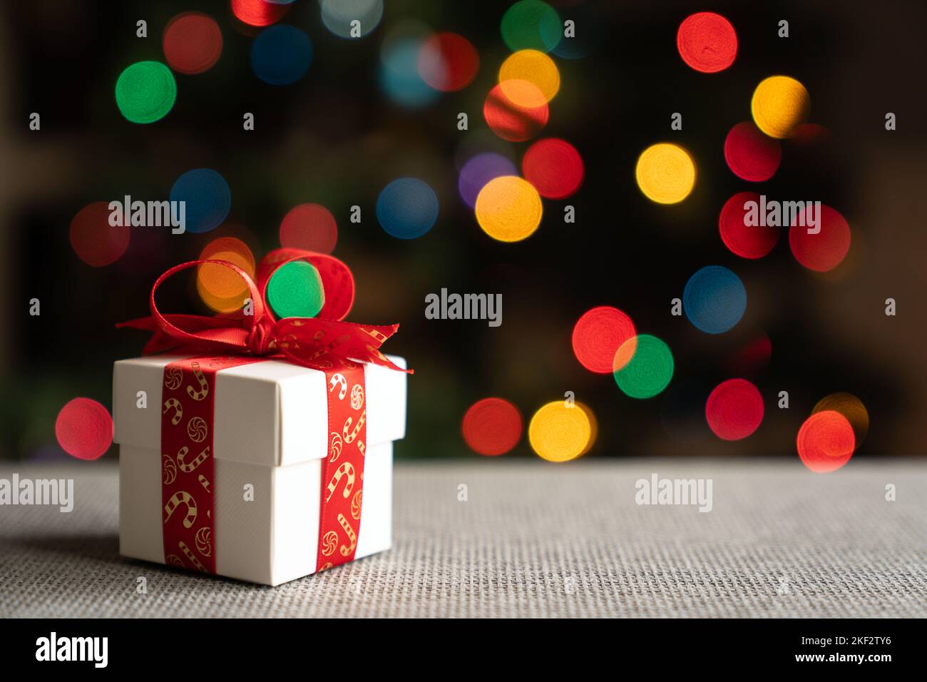 Geschenk vor dem weihnachtsbaum Stockfoto