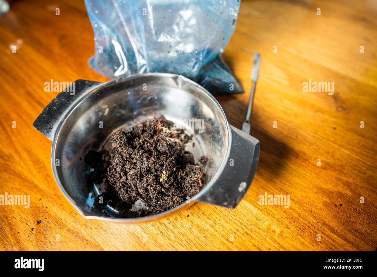 Durchführung eines Bodentests in einem Heimlabor. Boden auf einem Tisch. Brauner Schmutz auf einem Feld. Erdhaufen und Kompost Stockfoto