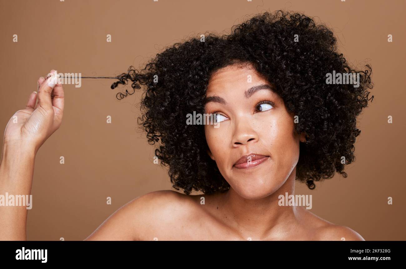 Schwarze Frau afro, unordentliche Haare und Locken auf der Suche nach Kosmetik oder Salonbehandlung vor einem braunen Studiohintergrund. Afroamerikanische Frau im Haar Stockfoto
