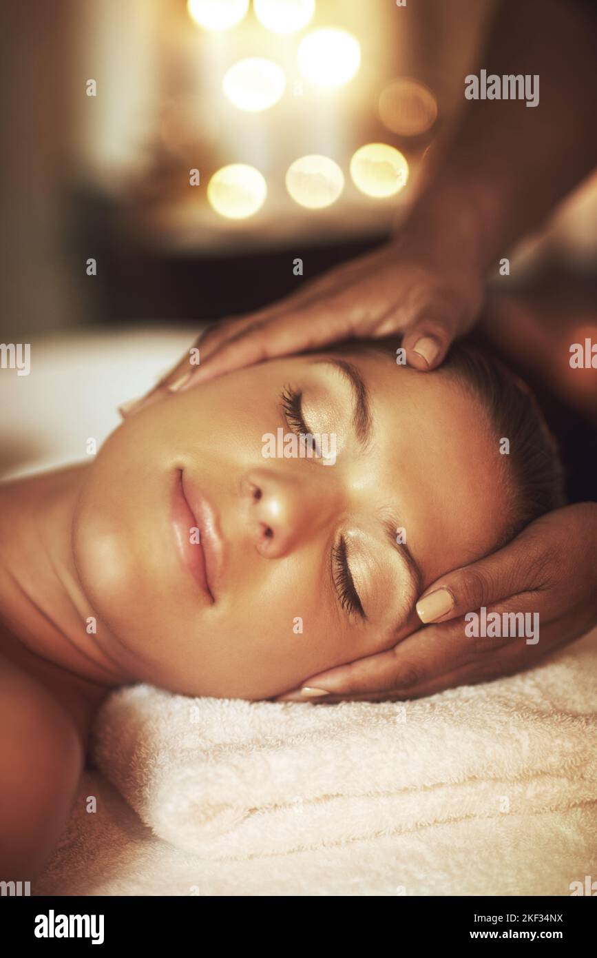 Massage hilft Entspannung. Nahaufnahme einer jungen Frau, die eine Kopfmassage im Spa genießt. Stockfoto