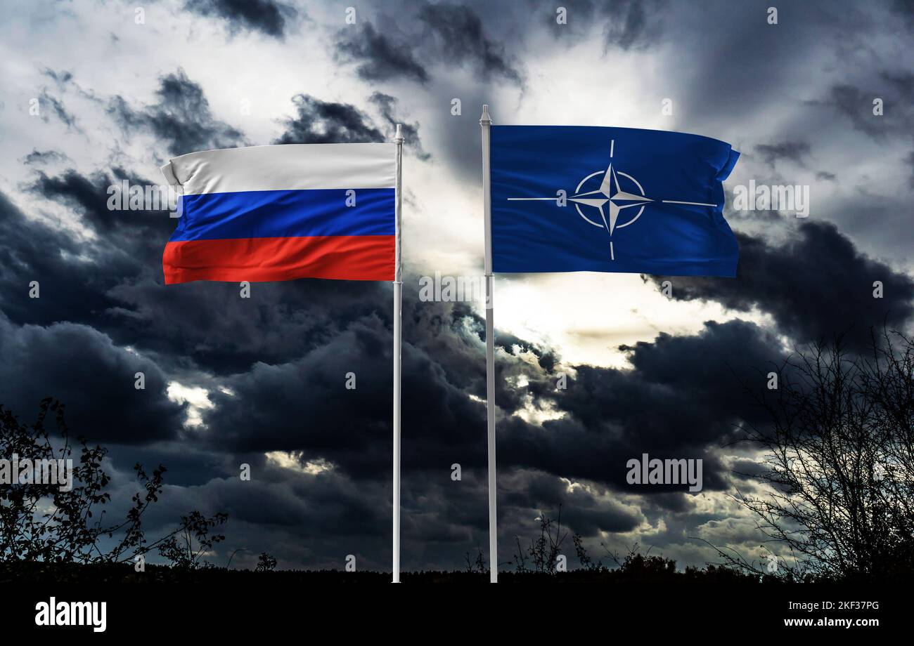 Flaggen der NATO und Russlands an der Wand mit großem Riss in der Mitte. Beziehungen zwischen der Organisation des Nordatlantikvertrags und Stockfoto