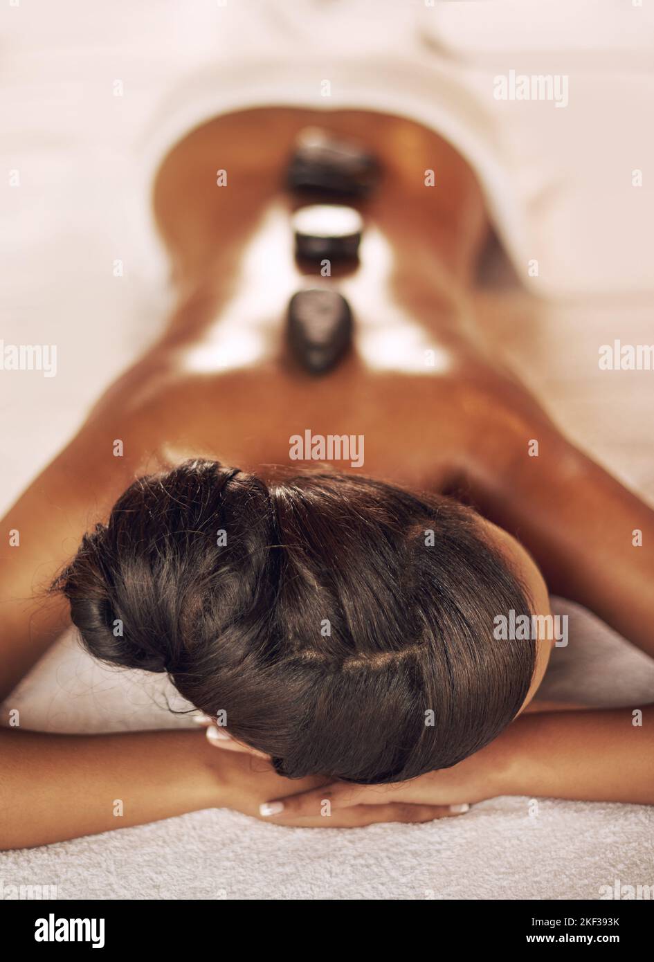 Heilung von heißen Steinen. Aufnahme einer jungen Frau, die im Spa eine Laton-Therapie genießt. Stockfoto