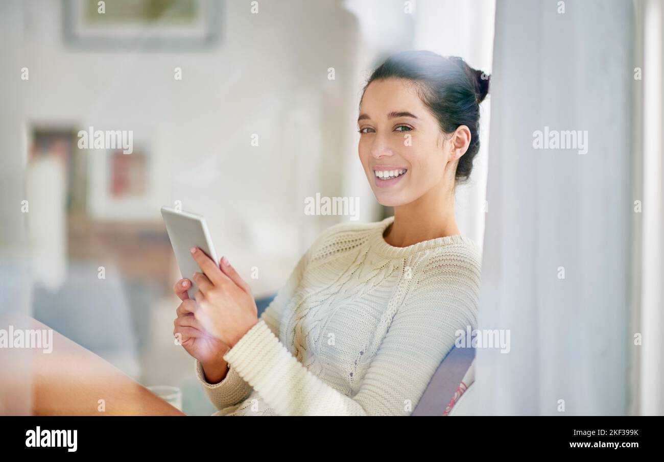Verbringen Sie etwas Freizeit online. Junge Frau entspannt mit einem digitalen Tablet zu Hause. Stockfoto