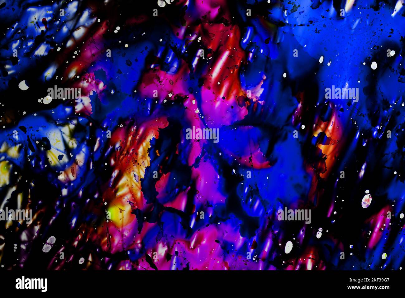 Eine lebhafte chaotische abstrakte Mischung aus blauen, roten, rosa und gelben Farbstoffen auf einer dünnen Folie aus leicht zerbrochenem Kunststoff auf einem Leuchtkasten Stockfoto